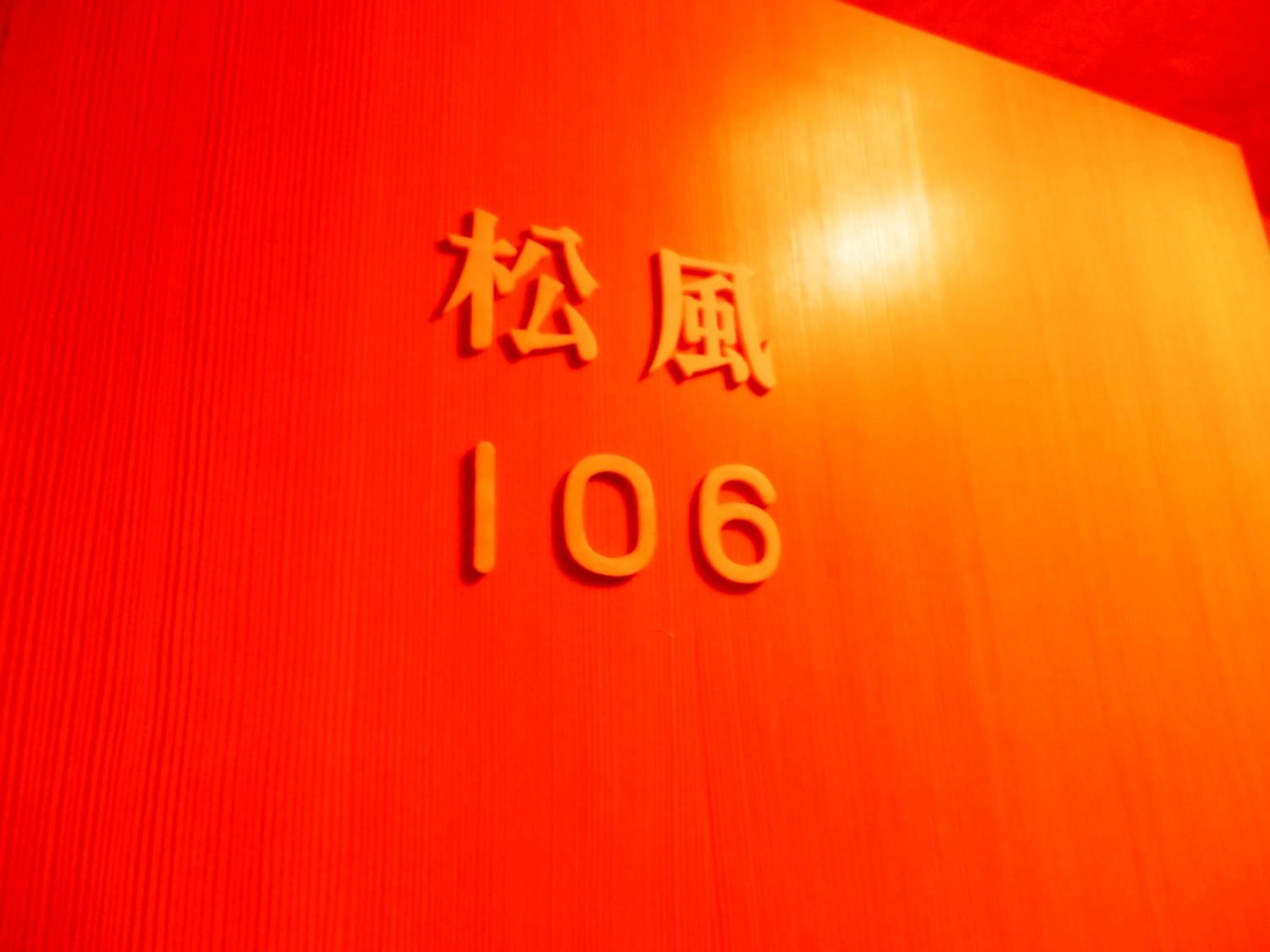 Una pared roja con los números 106 y los caracteres chinos 松楼.