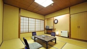 A traditional Japanese room with tatami flooring, a low table, and a television. - Nakayasu Ryokan (Kanazawa)
