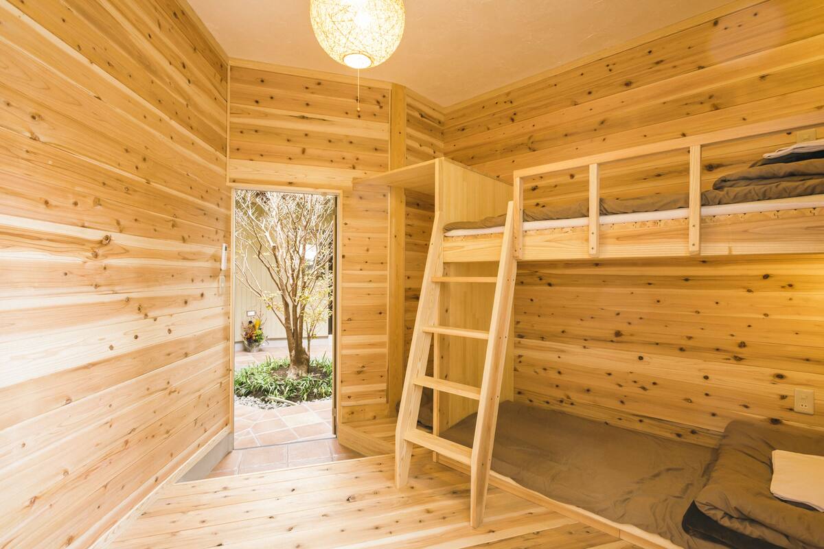 A wooden cabin interior with bunk beds and a ladder.