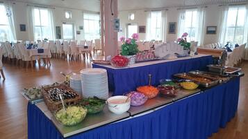 A buffet setup with various food items and a blue tablecloth.