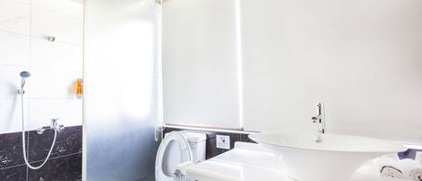 A modern bathroom with a toilet, bidet, and a sink.