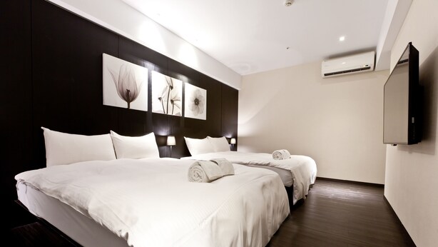 A modern hotel room with a large bed, a flat-screen TV, and artwork on the wall. - StayInn Taipei (Taipei)