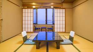 Une pièce de style japonais traditionnel, avec un sol recouvert de tatamis, une table basse, deux chaises et des paravents en papier de riz (shoji).