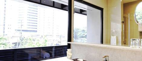 Casa de banho moderna com uma janela ampla, uma pia e um espelho.