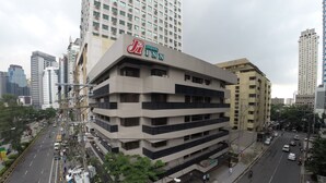 A multi-story building with a prominent sign for Jinjiang Inn. It features a modern architectural design with balconies and a flat facade. - Jinjiang Inn Ortigas (Pasig)