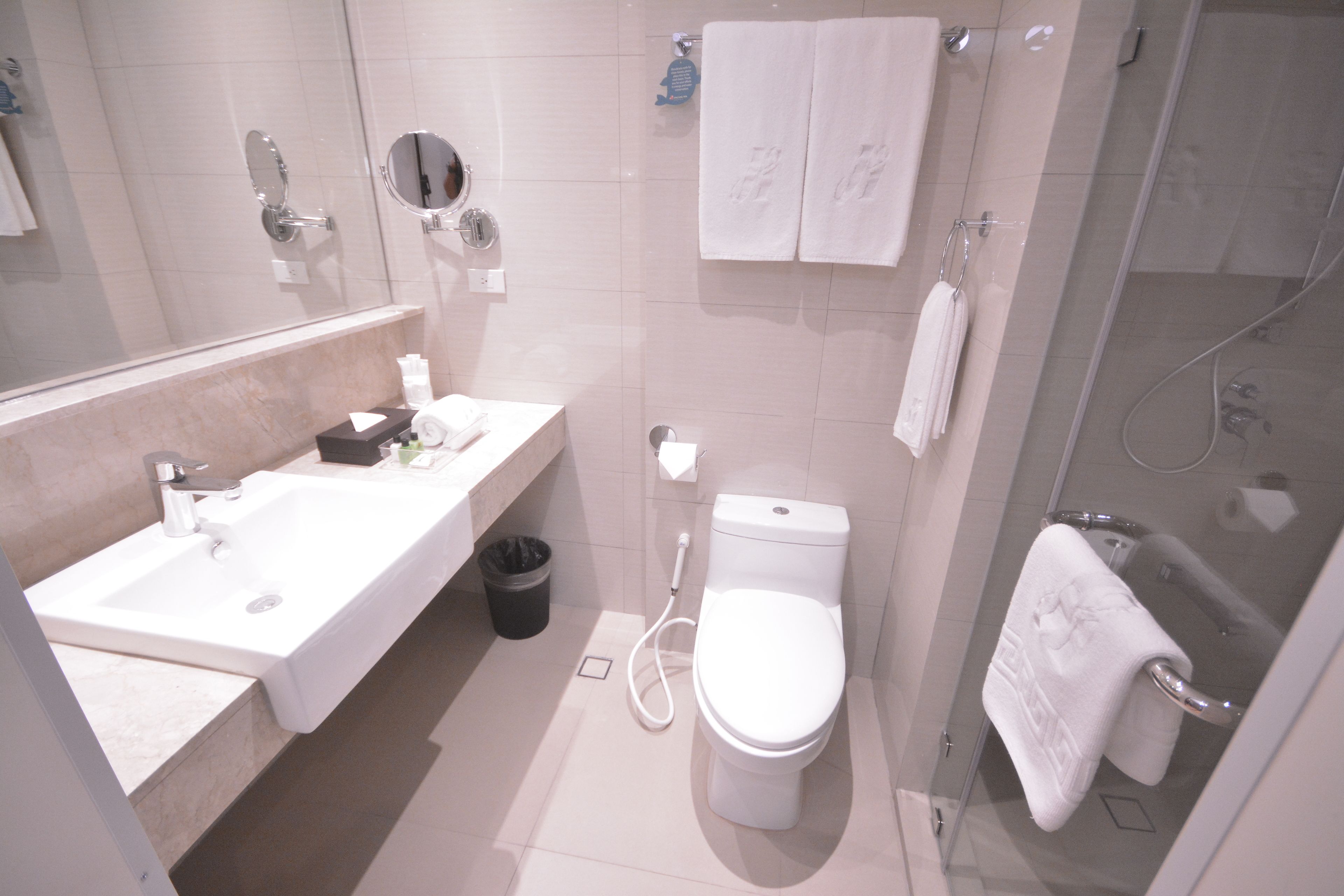 A modern bathroom with a sink, toilet, and shower.