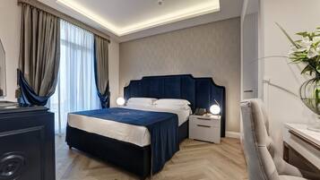 Une chambre d’hôtel moderne avec un grand lit, une table de chevet avec une lampe et un fauteuil.