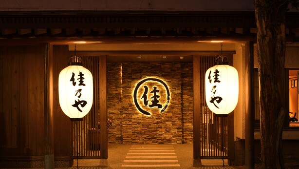 A traditional Japanese entrance with wooden doors and a stone wall. - Kusatsu Onsen Ryokan Yoshinoya (Kusatsu)