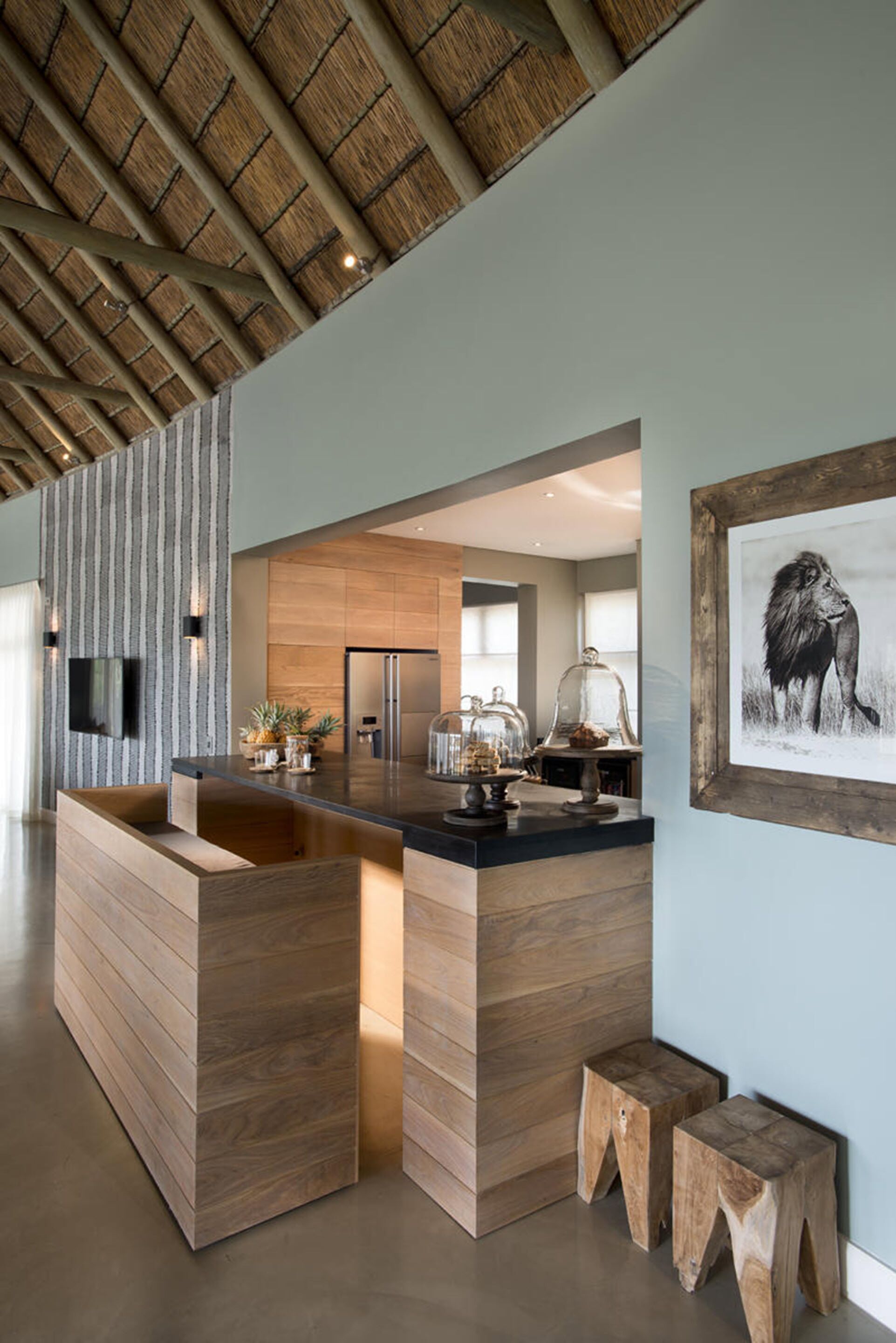 A modern kitchen with a central island, wooden accents, and a large framed picture on the wall.