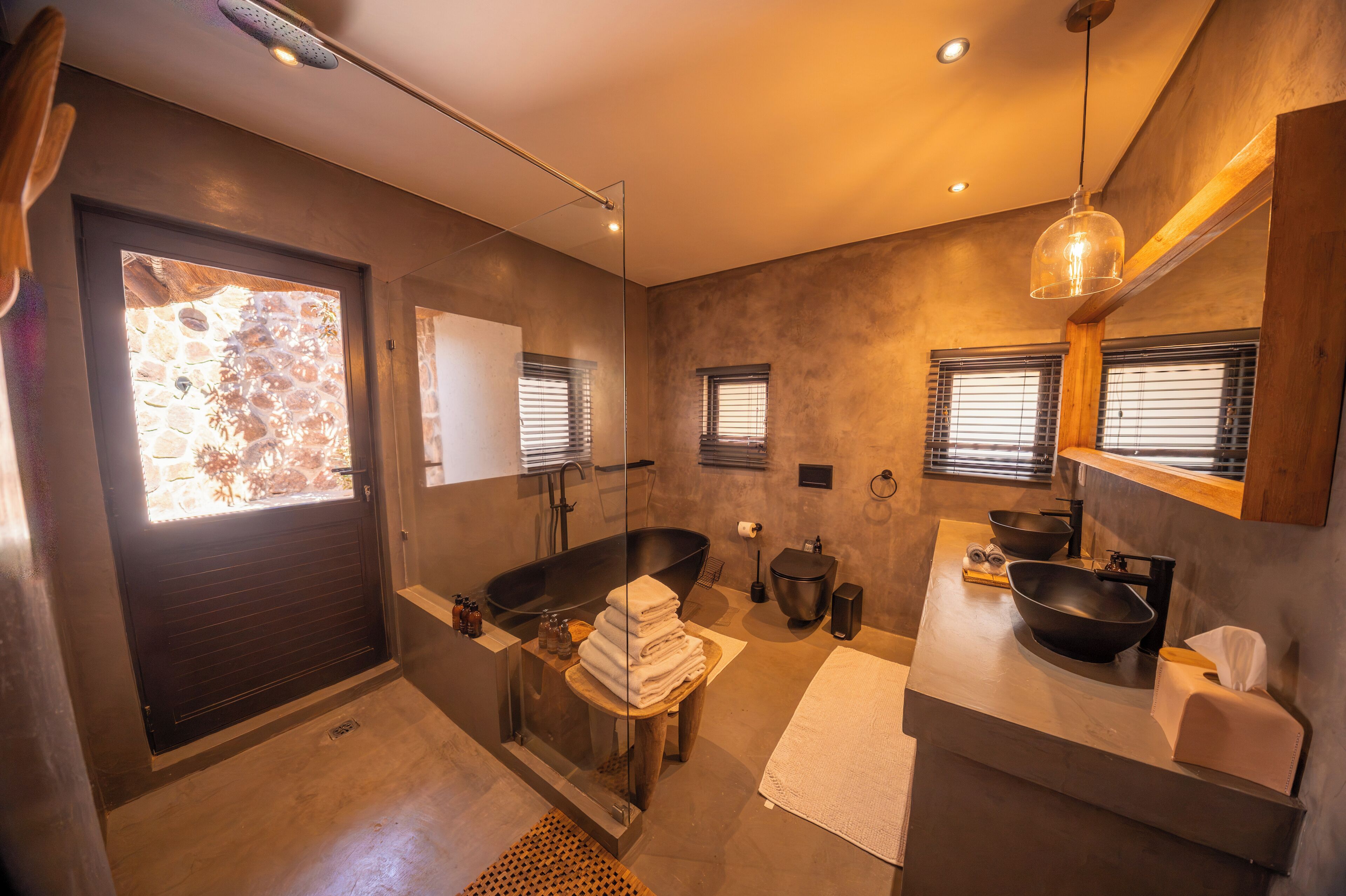 Un baño moderno con una bañera amplia, una ducha con cerramiento de vidrio y un tocador con lavamanos grande.