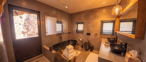 Un baño moderno con una bañera amplia, una ducha con cerramiento de vidrio y un tocador con lavamanos grande.