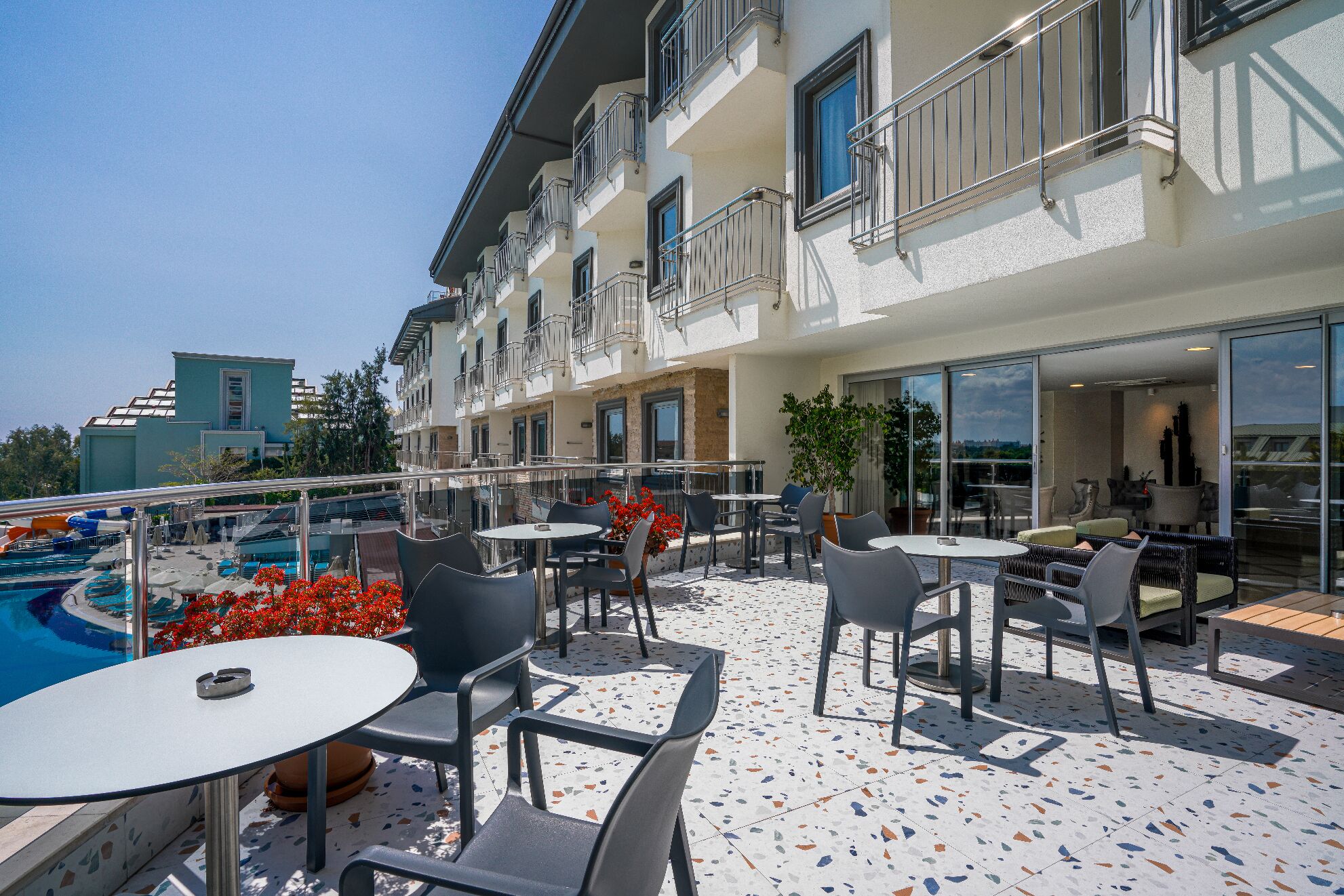 A rooftop terrace with outdoor seating, a swimming pool, and a view of the cityscape.