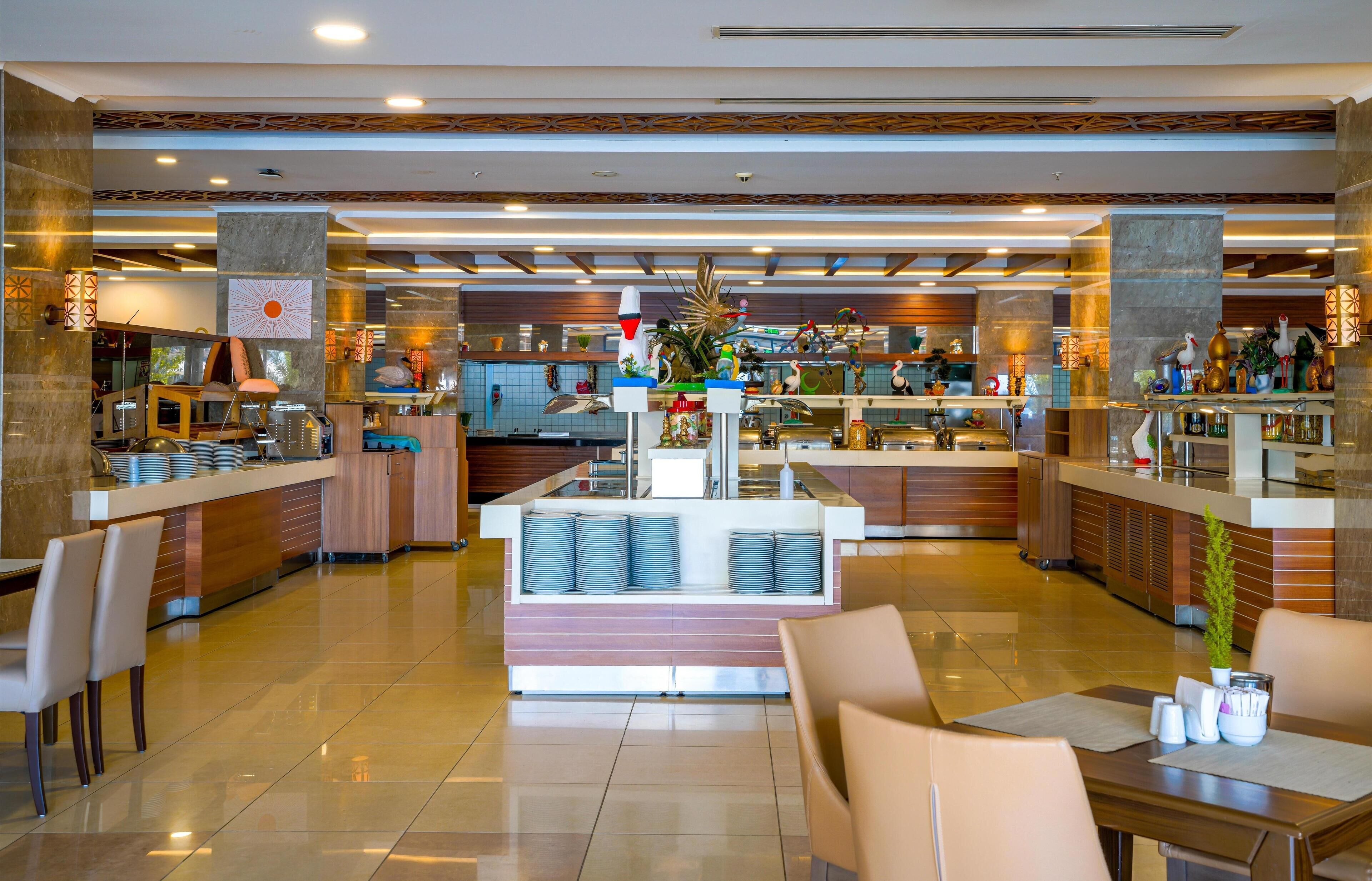 A modern hotel lobby with a central counter, seating areas, and a decorative plant.