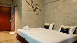 A hotel room with a large bed, two pillows, and a wall mural of a soccer player. - Happyland Mansion (Bangkok)