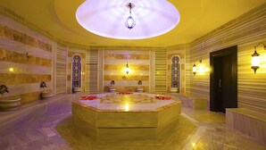A luxurious spa room with a central marble hot tub, decorative wall sconces, and a large skylight. - Diamond Elite Hotel & Spa - Adults Only (Manavgat)