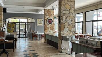 Un'ampia hall dell'hotel con reception, area salotto e vista sull'esterno.