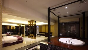 En modern hotellobby med ett stort ovalt badkar, en sittgrupp och en receptionsdisk.