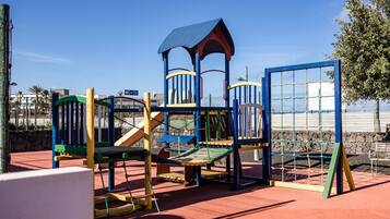 Un parque infantil con estructuras para escalar y un tobogán.