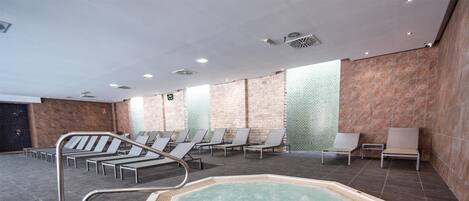 A spa area with a hot tub, lounge chairs, and a staircase leading to an upper level.