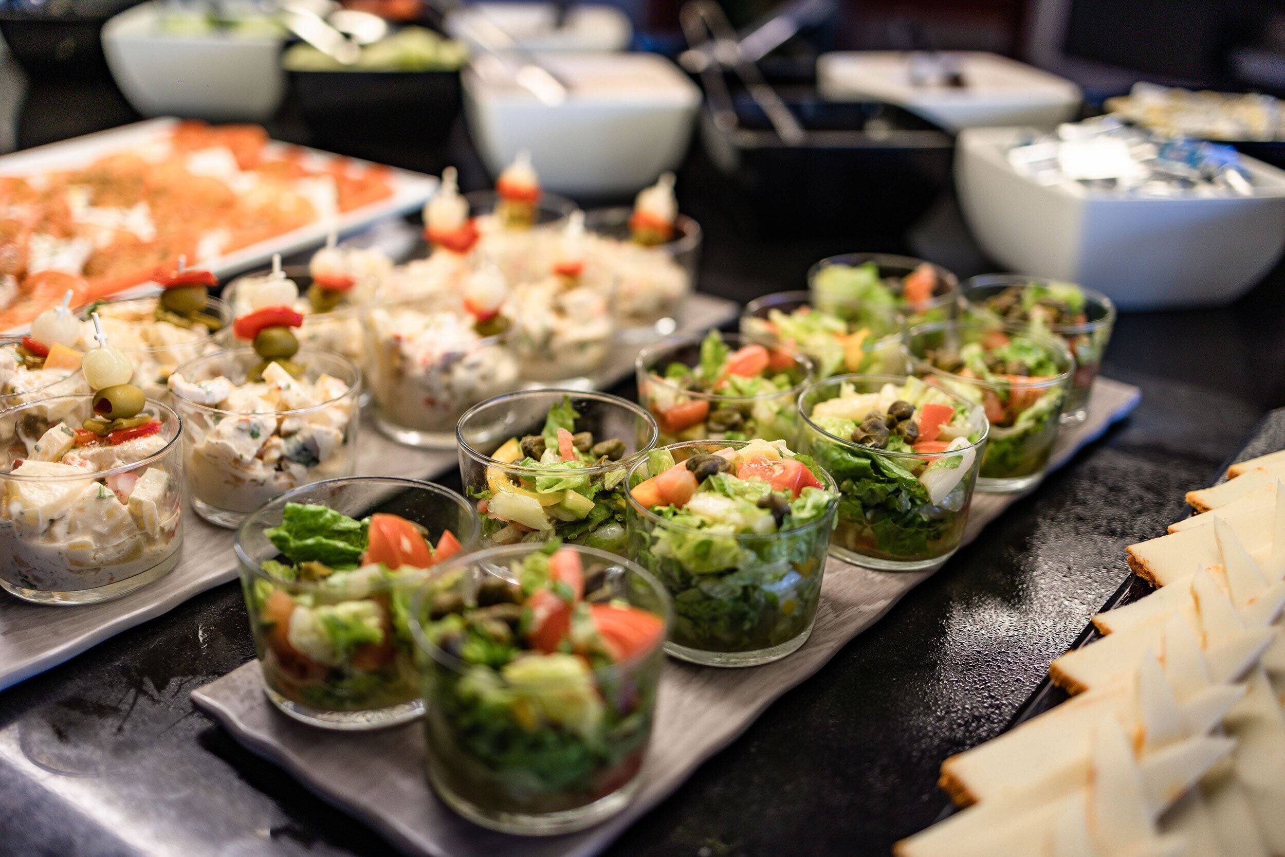 A buffet table with various food items including salads and appetizers.