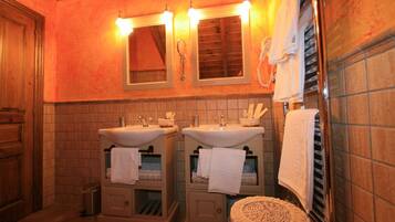 Une salle de bain avec deux lavabos, un miroir et un porte-serviettes.