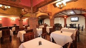 A restaurant with brick arches, wooden beams, and white tablecloths. - Posada Spa Privilegio de Vara (Noja)