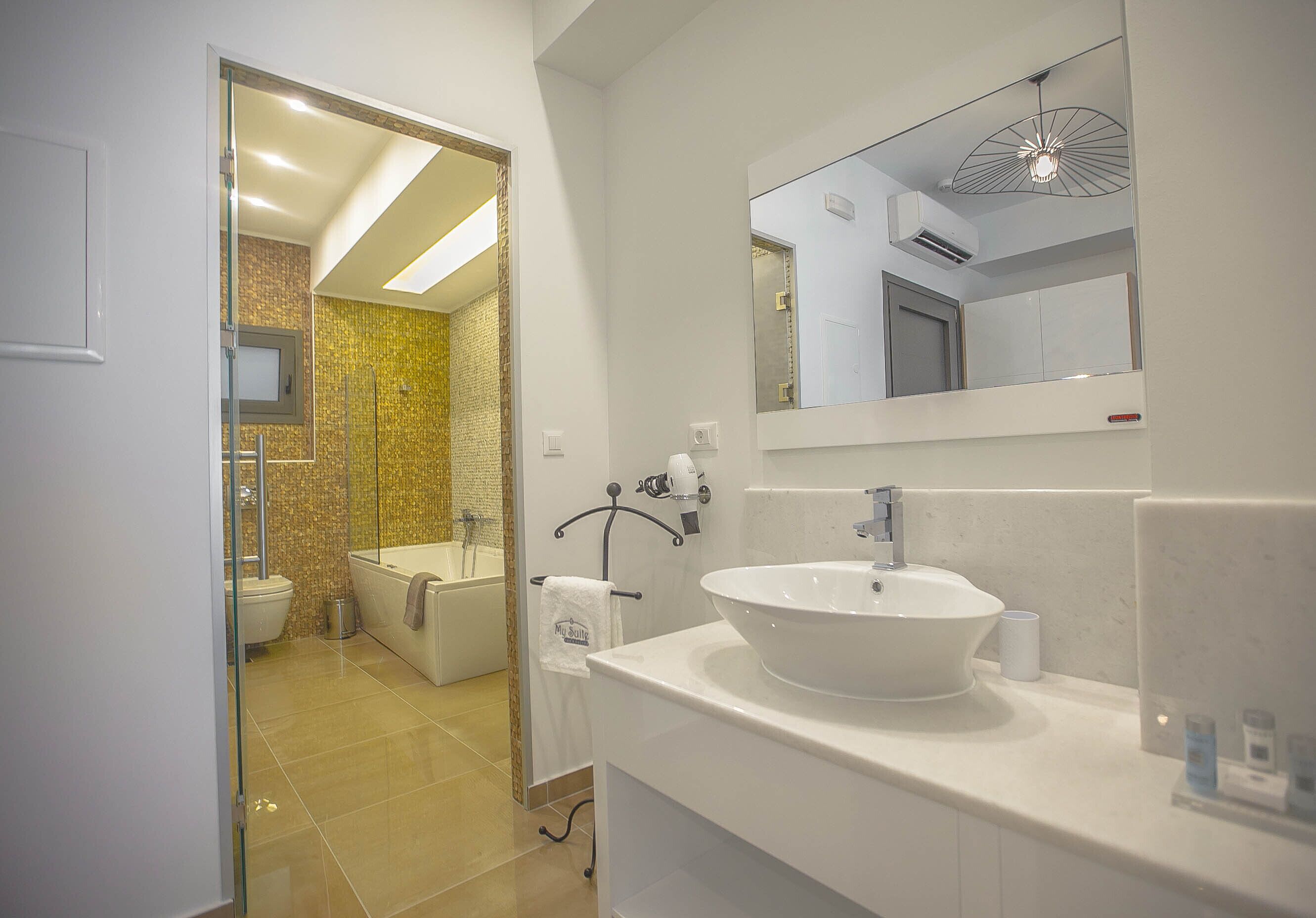 Un bagno moderno con un lavandino ampio, uno specchio e uno spazio doccia.