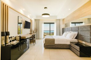 Relax in a spacious room with a large bed, flat-screen TV, and desk area.