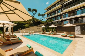 Relax by the pool surrounded by lounge chairs and umbrellas.