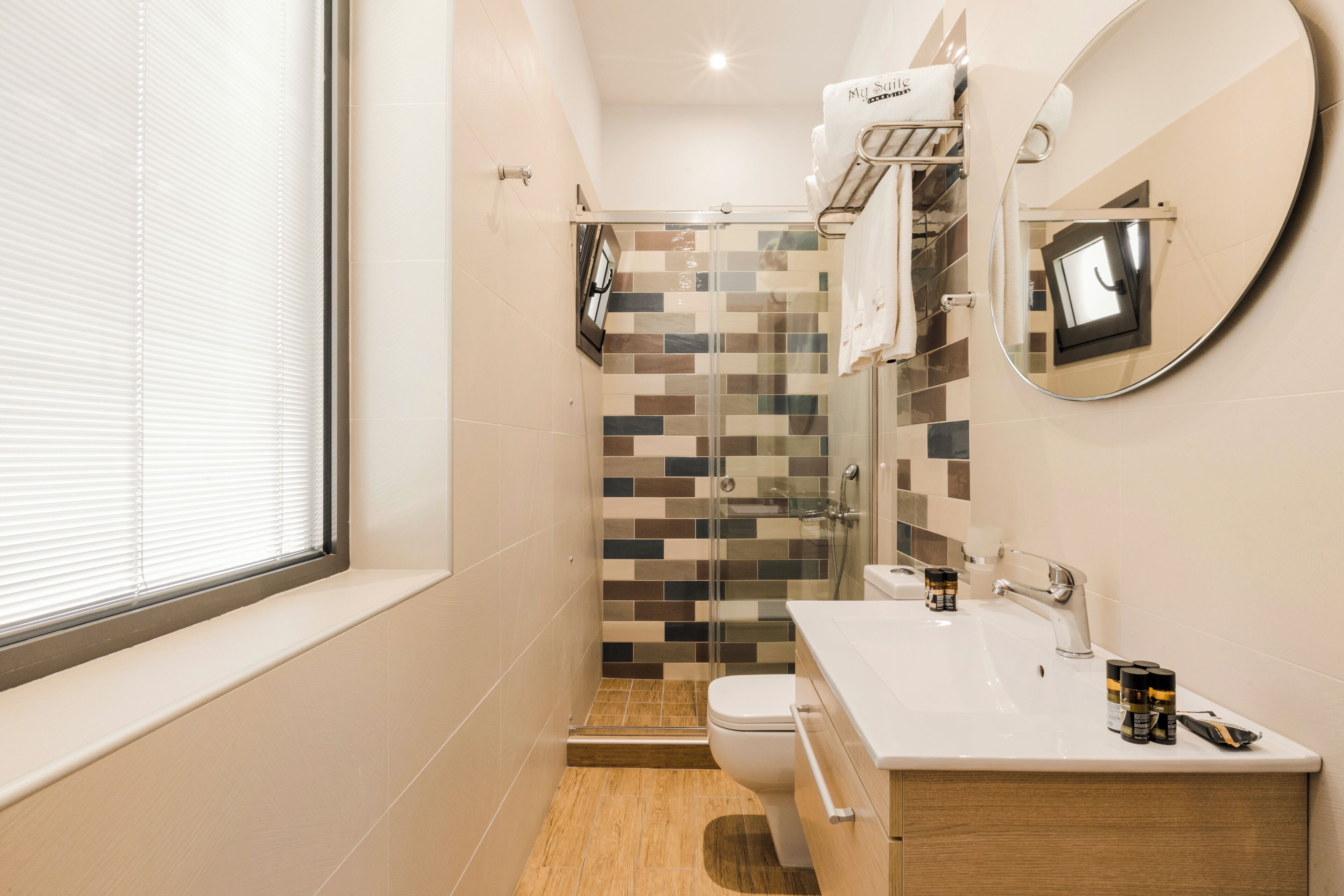 A modern bathroom with a toilet, sink, and shower.