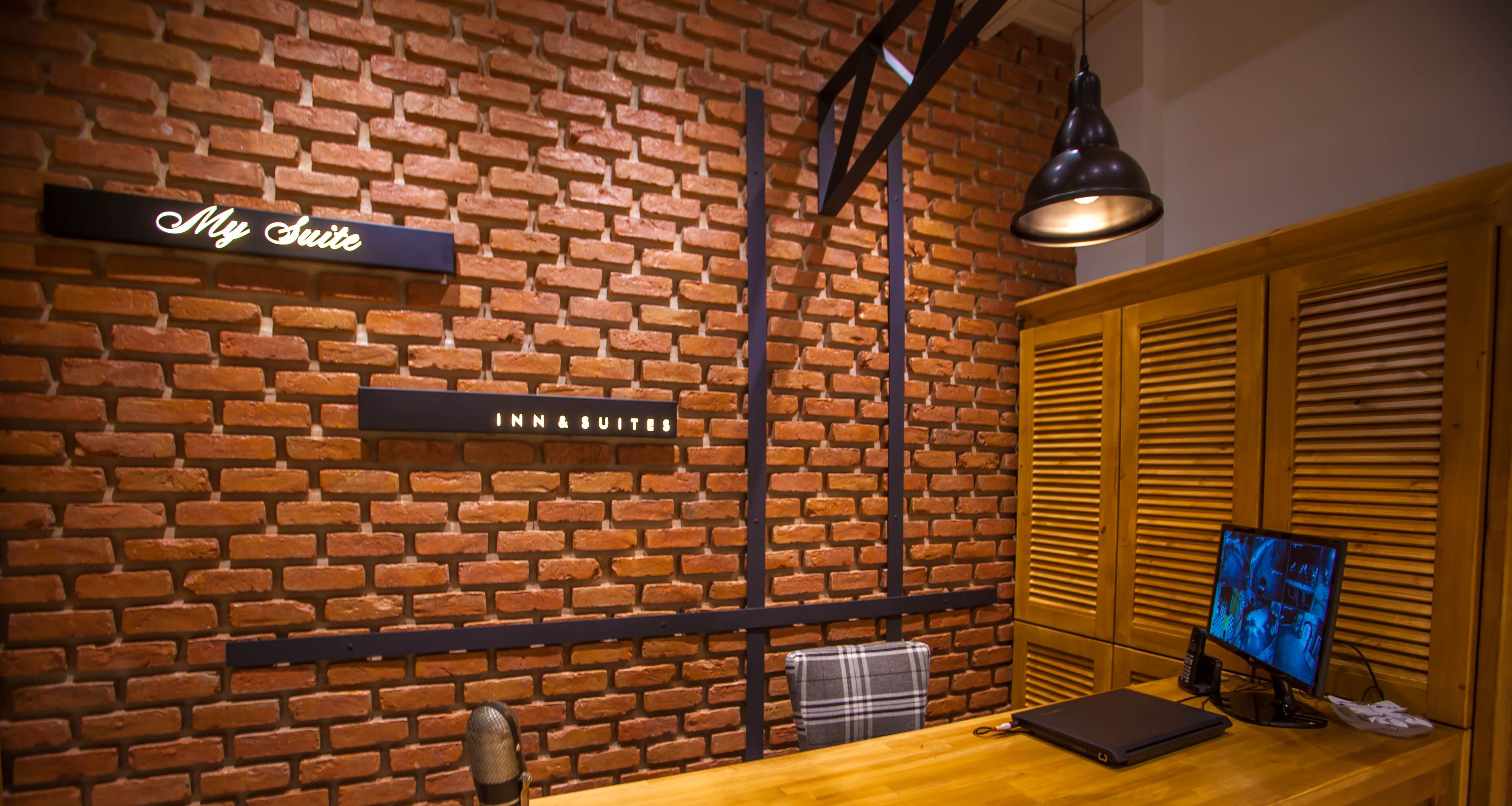 A brick wall with a sign reading "My Suite" and "INN & SUITES".