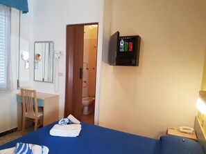 A hotel room with a bed, a desk, a chair, a mirror, a bathroom visible through an open door, and a medicine cabinet on the wall. - Hotel Villa Ersilia Rimini B&B (Rimini)