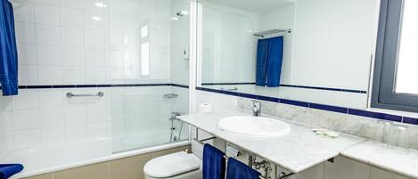 A modern bathroom with a bathtub, toilet, and sink.