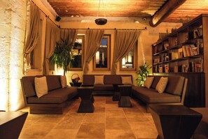 A cozy living room with a sectional sofa, a coffee table, and a bookshelf.