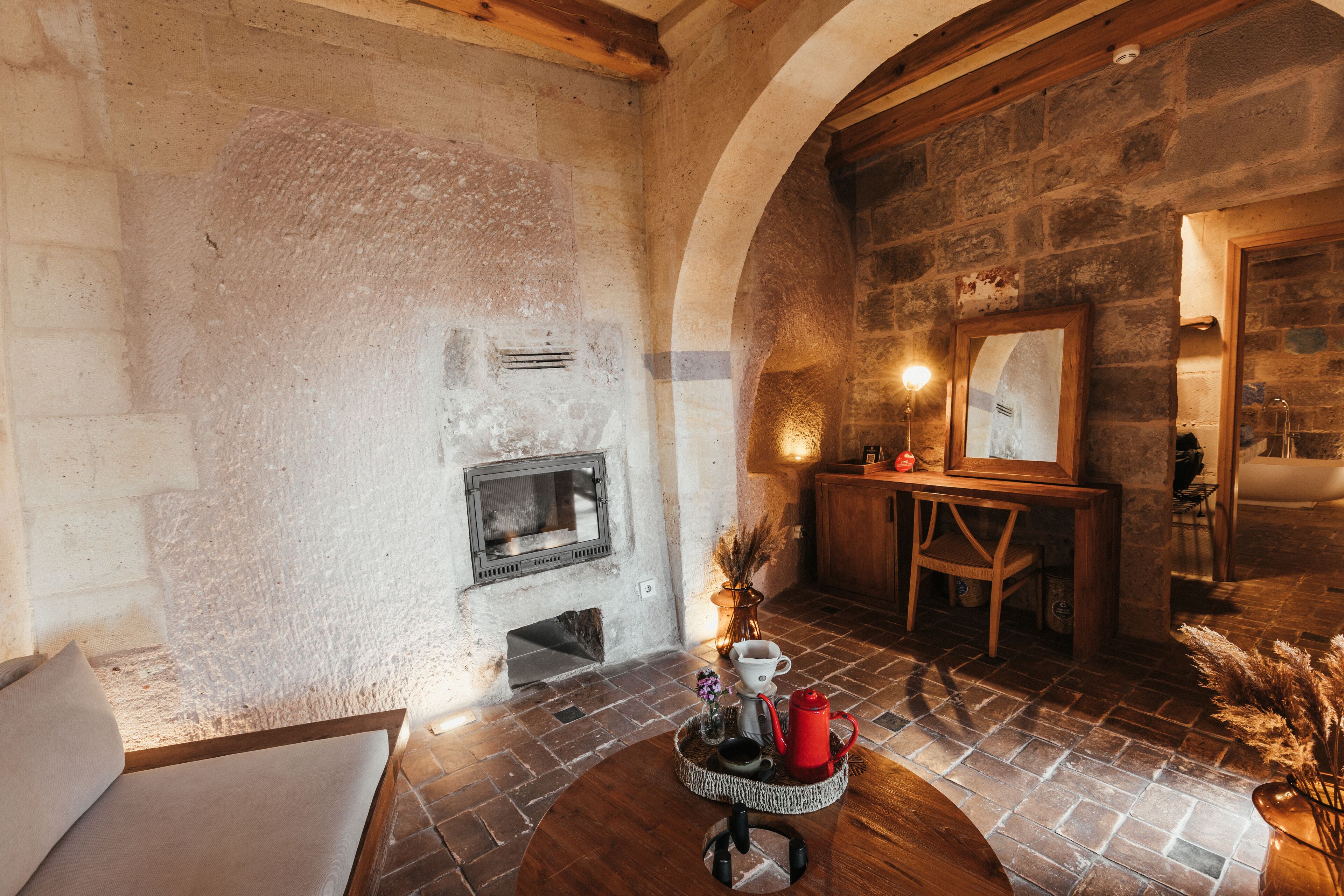 A rustic interior with a stone fireplace, wooden furniture, and a dining area.