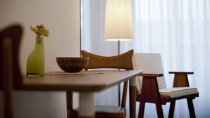 En matplats med ett bord, stolar, en lampa och en vas med blommor.