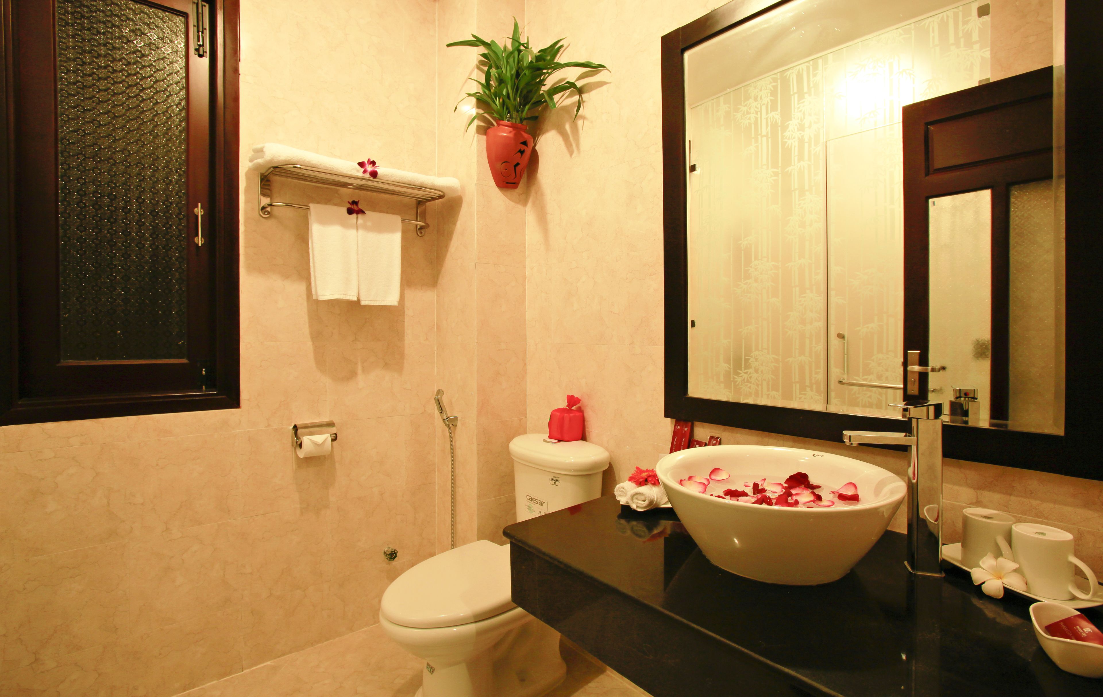 A bathroom with a toilet, sink, and mirror.