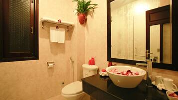 A bathroom with a toilet, sink, and mirror.