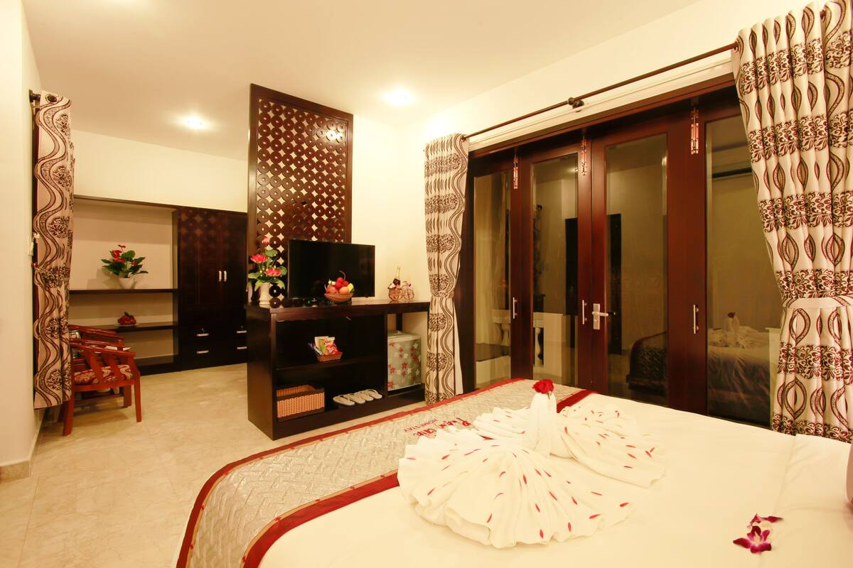 Une chambre d’hôtel équipée d’un lit, d’une télévision, d’une armoire, d’un bureau et d’une chaise.