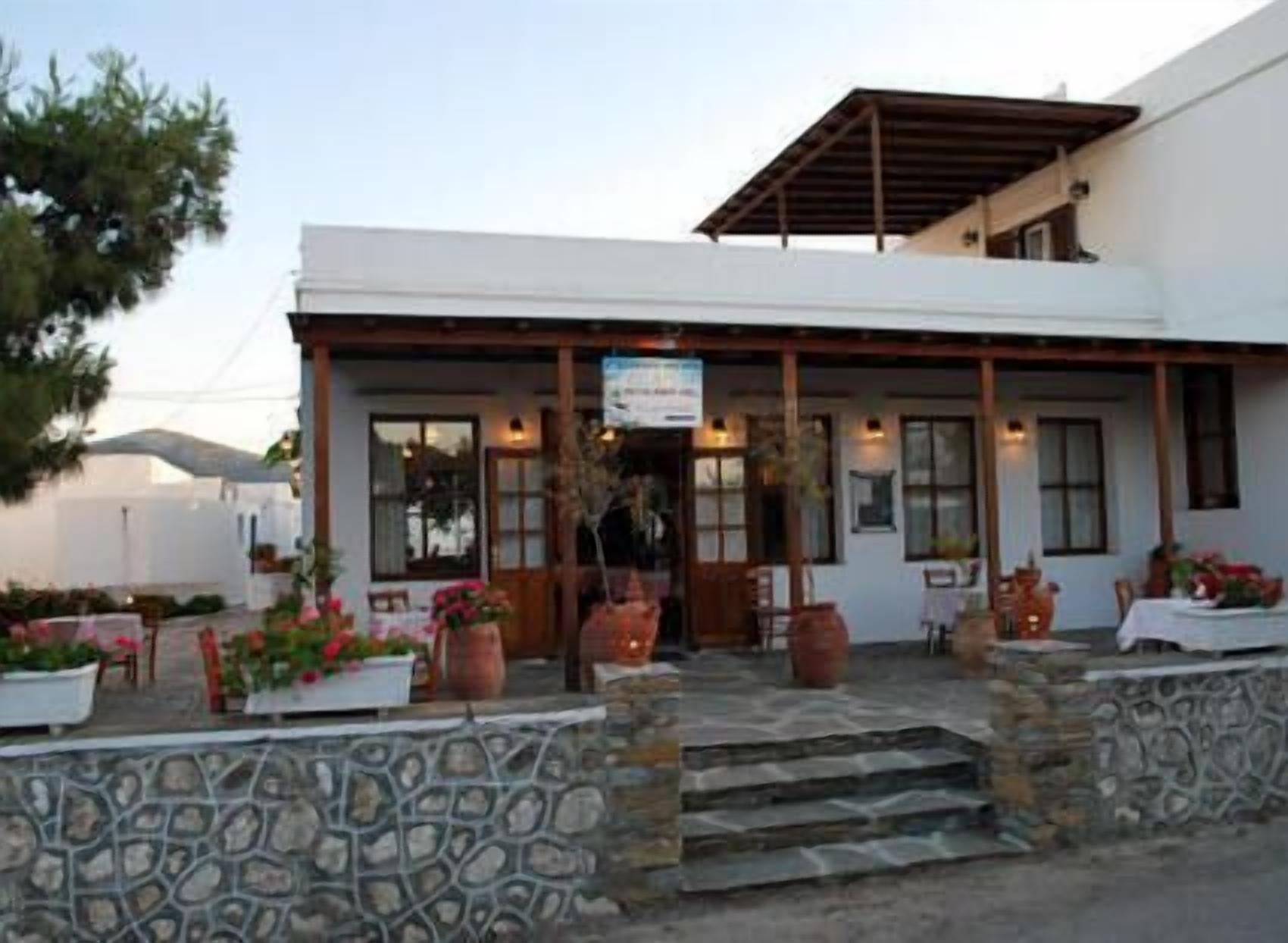 A building with a stone facade, a covered porch, and outdoor seating.