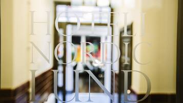 A blurred interior view of a hotel corridor with the text "HOTEL NORDIC LUND" visible.