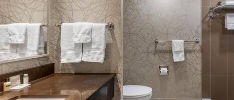 A bathroom with a sink, toilet, and shower area.