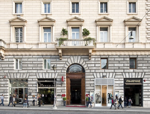 A historic building with a central entrance, multiple windows, and storefronts on the ground floor.