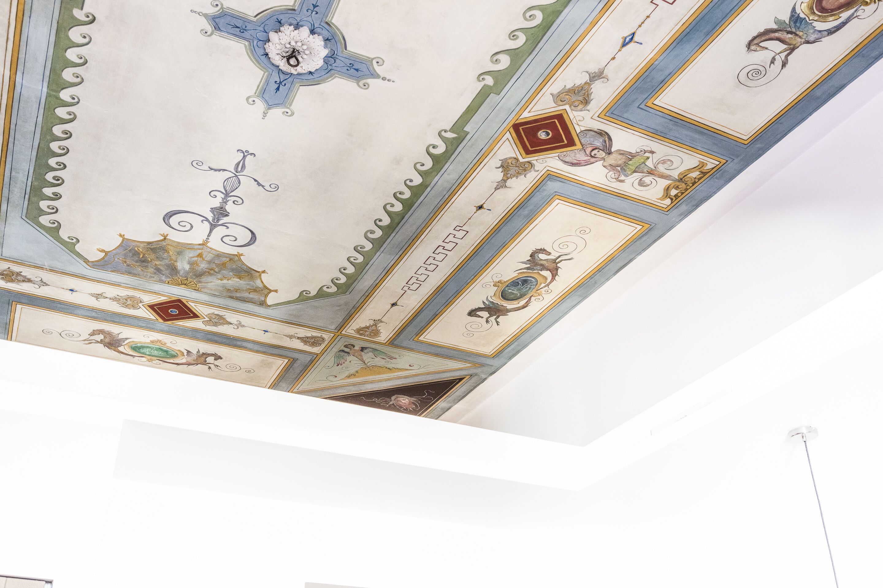 A ceiling with intricate designs including a cross, floral patterns, and geometric shapes.