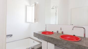 Un baño moderno con dos lavamanos, ducha y bañera.