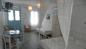 Una habitación con cama, escritorio, silla, televisión y ventana.