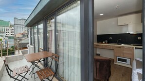 Un appartement moderne doté d’un balcon, d’une kitchenette et d’un coin repas.