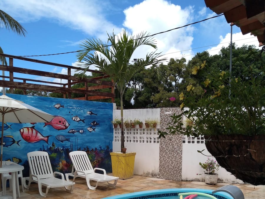 A swimming pool with lounge chairs and a mural of fish.