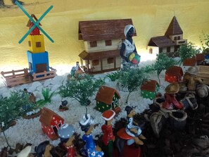 A nativity scene with miniature figures, including a shepherd, a stable, and a nativity scene. - Suítes São Francisco (Ipojuca)