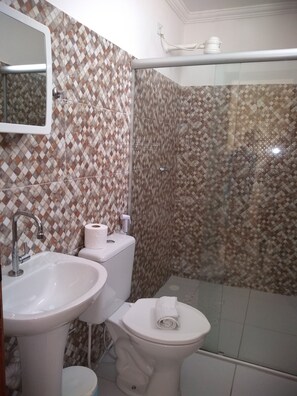 A bathroom with a sink, toilet, and shower area. - Suítes São Francisco (Ipojuca)